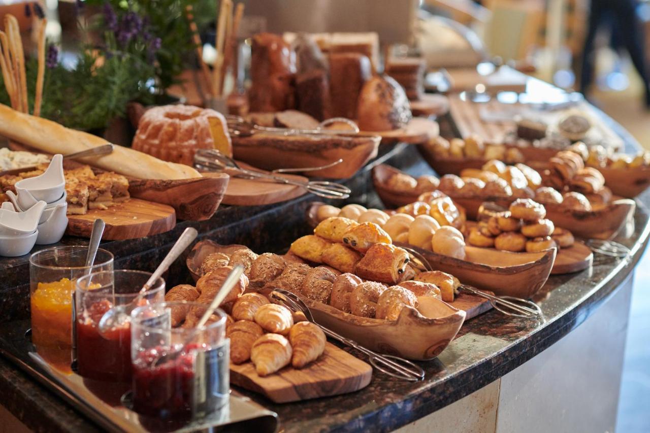 Regent Warsaw Hotel Buitenkant foto The photo shows a beautifully arranged spread of baked goods on a countertop. There are various types of bread, pastries, and rolls displayed on wooden boards and in bowls. Some items appear to be sweet, while others seem savory. Additionally, there 